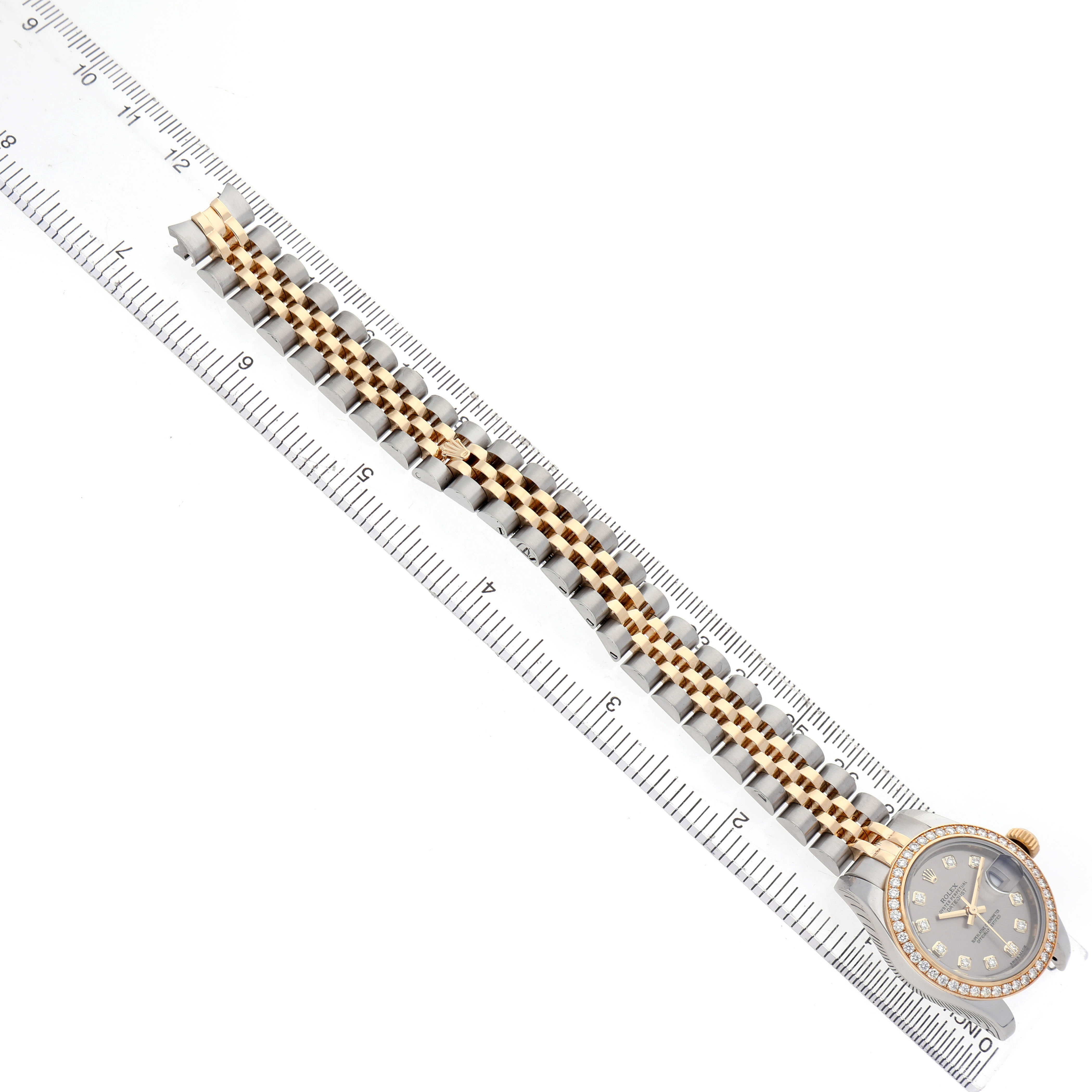 The Rolex Datejust 179383 Women's Steel and Gold (two tone) Grey Dial watch is shown from a top view, displaying the entire bracelet and face against a ruler.