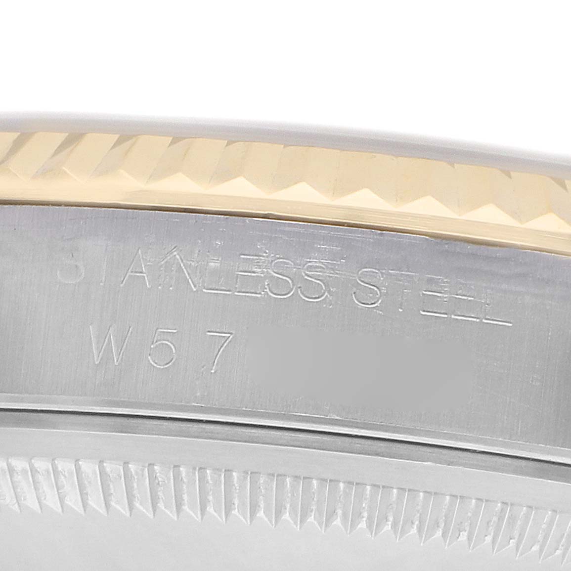 The image shows a close-up of the side of a Rolex Datejust 16233 Men
s Steel and Gold (two tone) Beige Dial with engravings on the steel case and a fluted bezel.