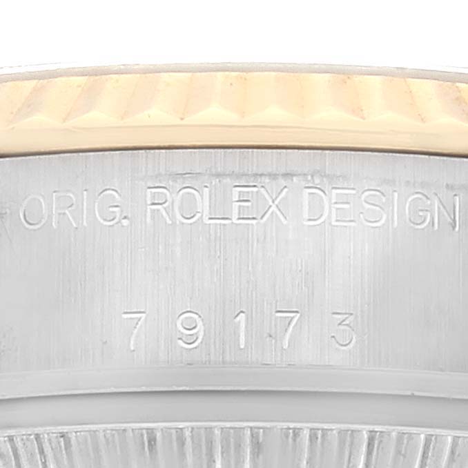 The image shows a close-up of the engraved serial number and "ORIG. ROLEX DESIGN" on a Rolex Datejust 79173 Women's Steel and Gold (two tone) Silver Dial 79173 Women's Steel and Gold (two tone) Silver Dial watch case.
