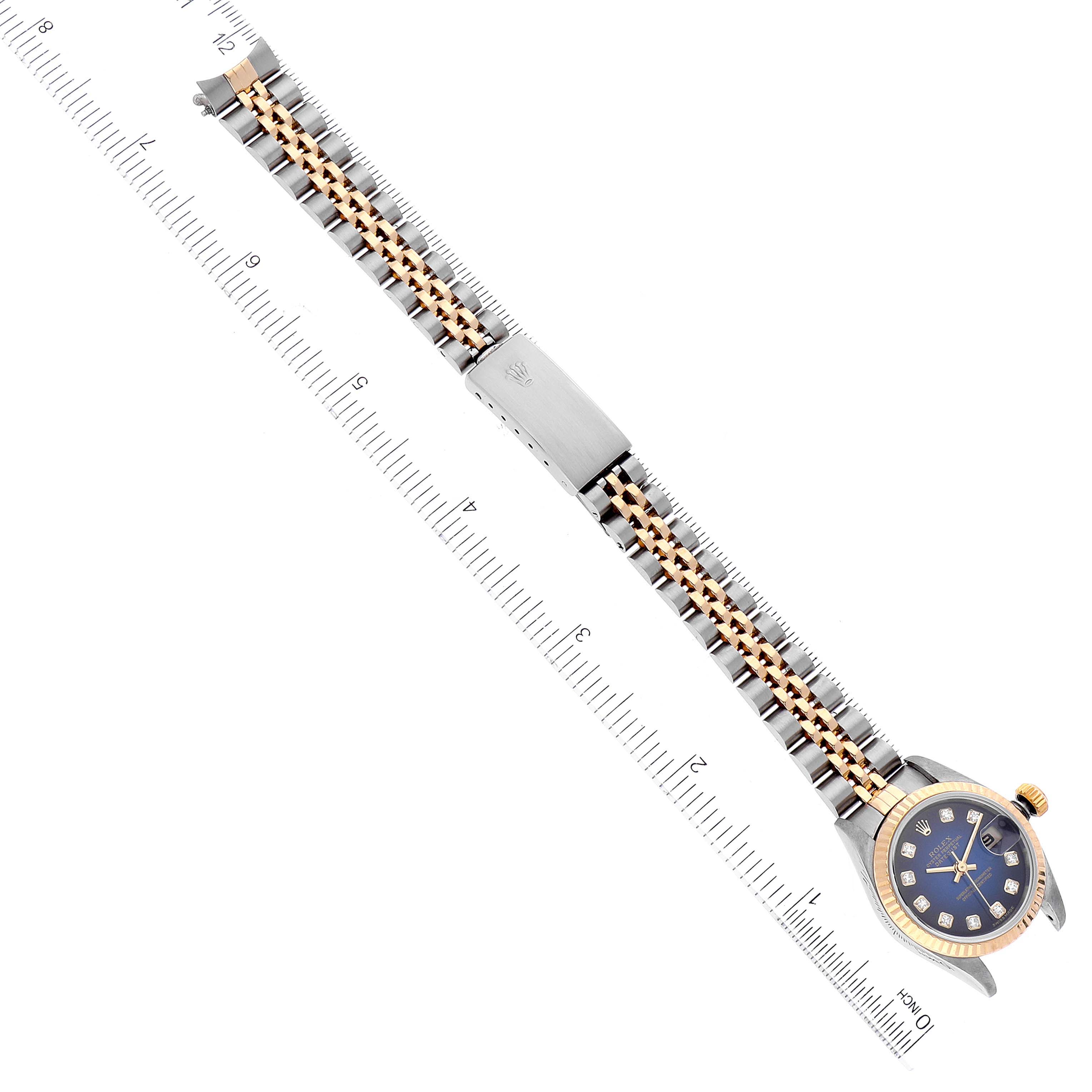 The image shows a Rolex Datejust 79173 Women's Steel and Gold (two tone) Blue Dial 79173 Women's Steel and Gold (two tone) Blue Dial watch from a top-down angle, displaying the full watch and band placed on a ruler.