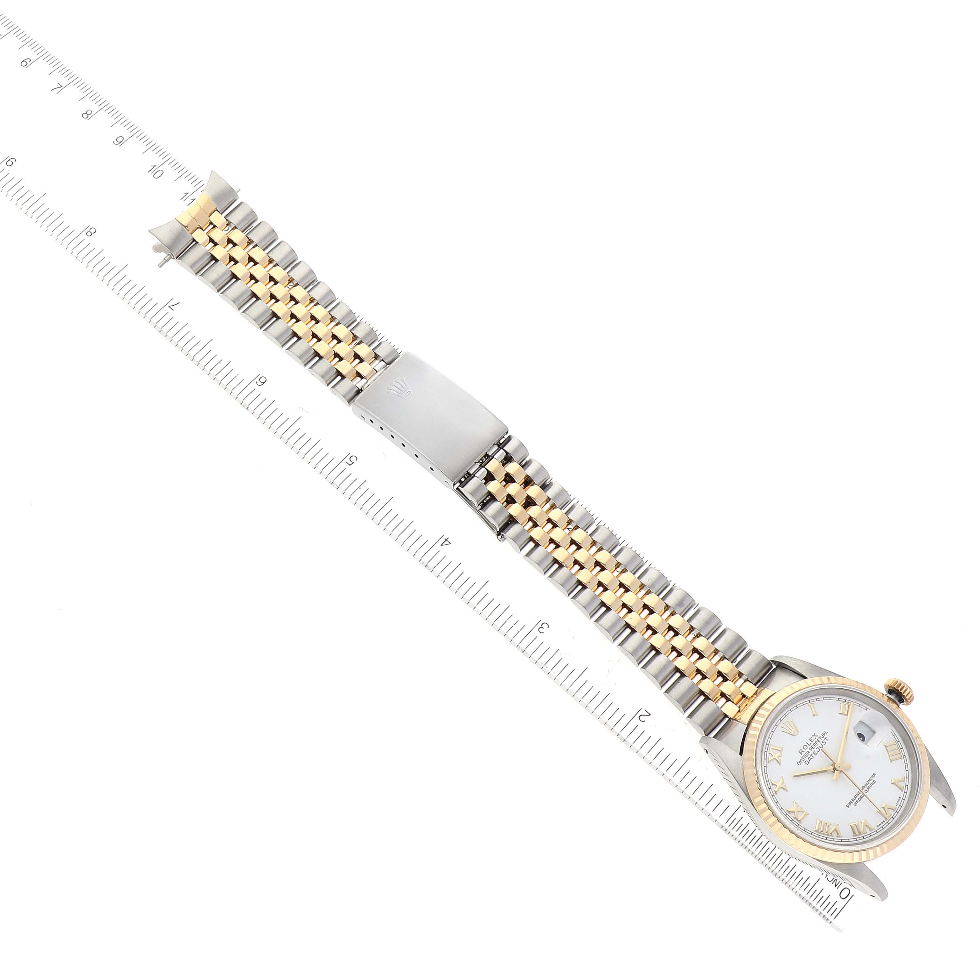 The Rolex Datejust 16233 Men's Steel and Gold (two tone) White Dial 16233 Men's Steel and Gold (two tone) White Dial watch is shown at an angle, displaying its face, bracelet, and clasp next to a ruler.