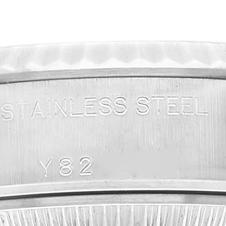 This close-up image of the Rolex Datejust 79174 Women's Stainless Steel Orange Dial 79174 Women's Stainless Steel Orange Dial watch shows the "Stainless Steel" engraving on its case back.