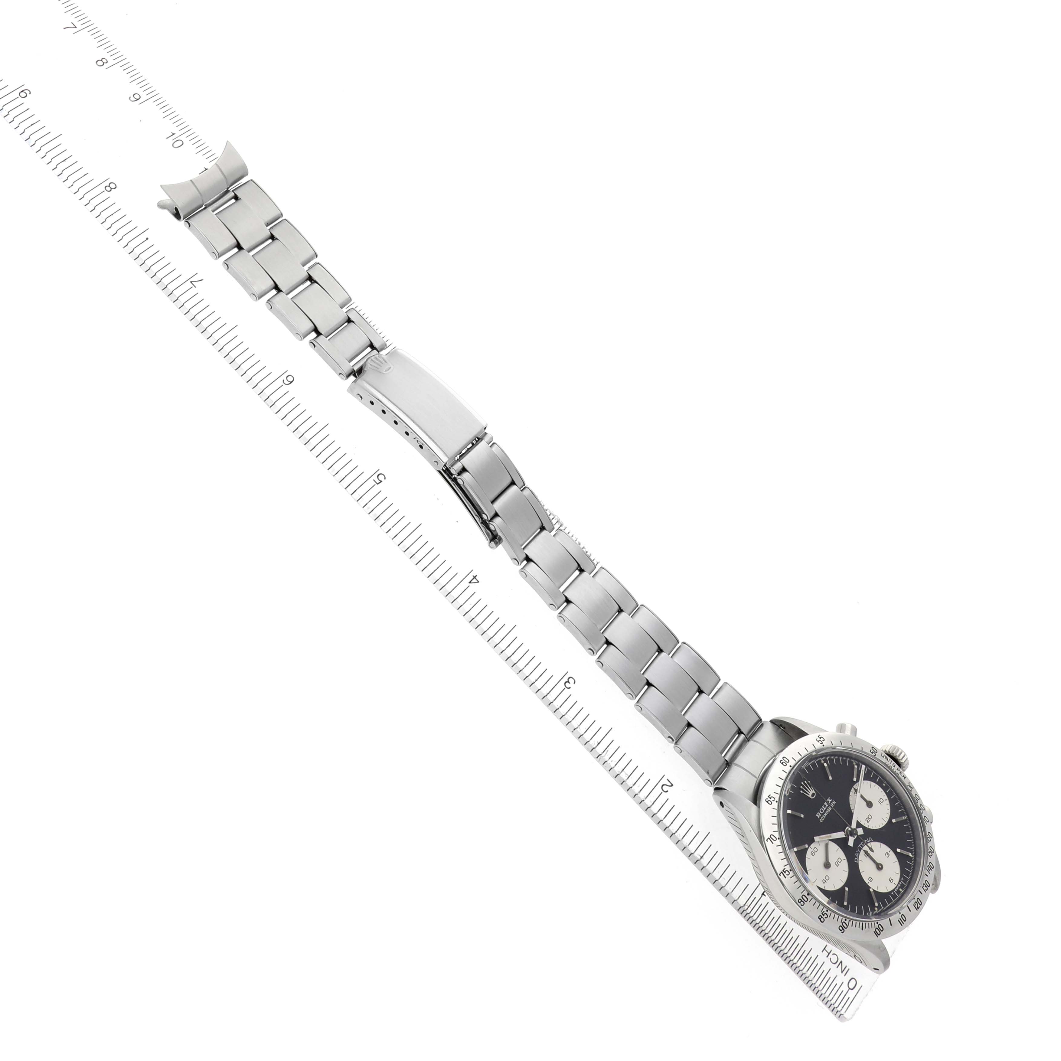 The image shows a Rolex Daytona 6239 Men
s Stainless Steel Black Dial watch at an angle, displaying the face, bezel, and full bracelet alongside a ruler.