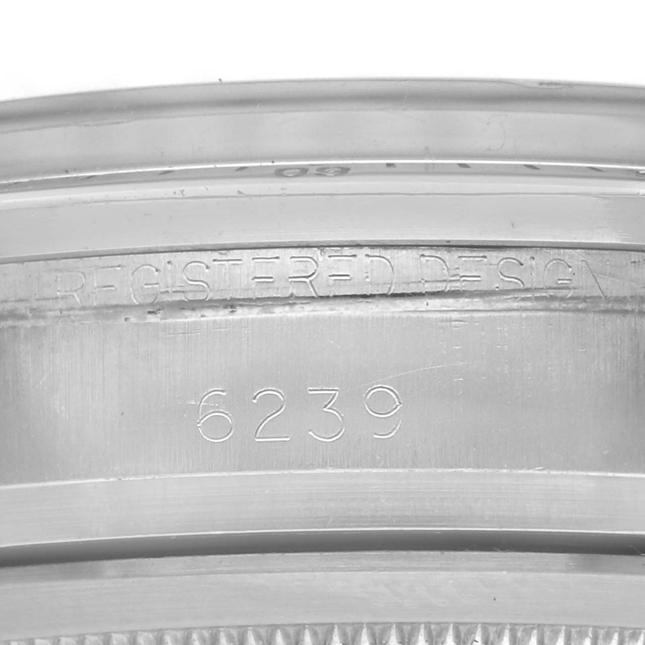 The image shows a close-up of a Rolex Daytona 6239 Men
s Stainless Steel Black Dial 6239 model
s engraved design and serial number on the case side.