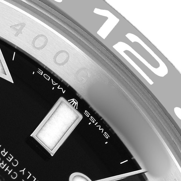 The image shows a close-up angle of the Rolex GMT-Master 126710GRNR Men's Stainless Steel Black Dial bezel, dial, and part of the chapter ring.