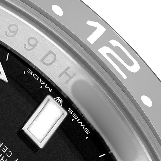 The image shows a close-up of the Rolex GMT-Master 126710GRNR Men's Stainless Steel Black Dial bezel and part of the dial, highlighting the "12" marker and "SWISS MADE" text.
