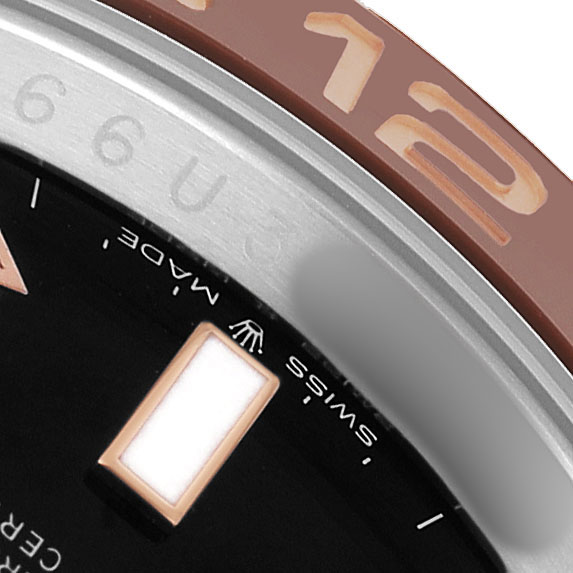The image shows a close-up of the Rolex GMT-Master 126711 Men's Steel and Gold (two tone) Black Dial's bezel and part of the dial with markers.