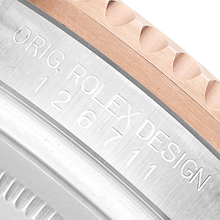 The image shows a close-up of the Rolex GMT-Master 126711 Men's Steel and Gold (two tone) Black Dial model's bezel and engraved edge.