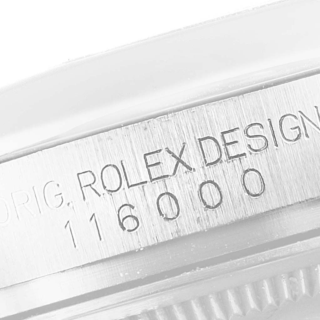 This image shows a close-up of the case side with model number engraving from a Rolex Oyster Perpetual 116000 Men's Stainless Steel Champagne Dial 116000 Men's Stainless Steel Champagne Dial watch.