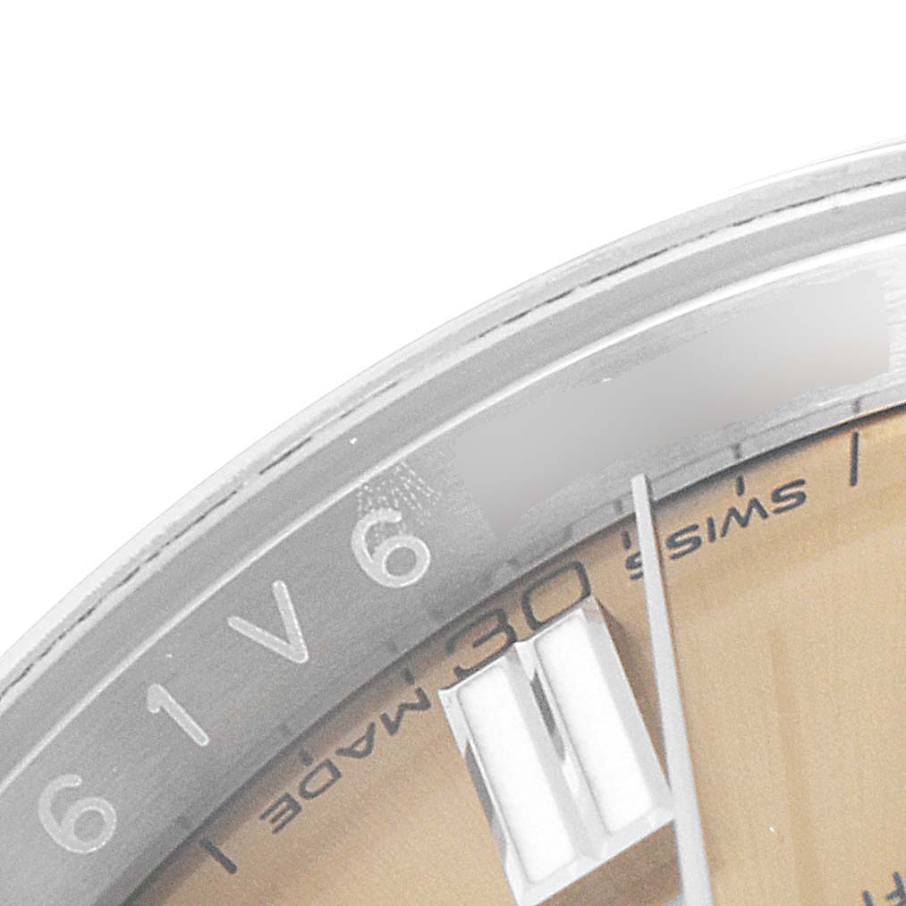 This image shows a partial close-up of the dial, bezel, and a marker of the Rolex Oyster Perpetual 116000 Men's Stainless Steel Champagne Dial 116000 Men's Stainless Steel Champagne Dial watch.