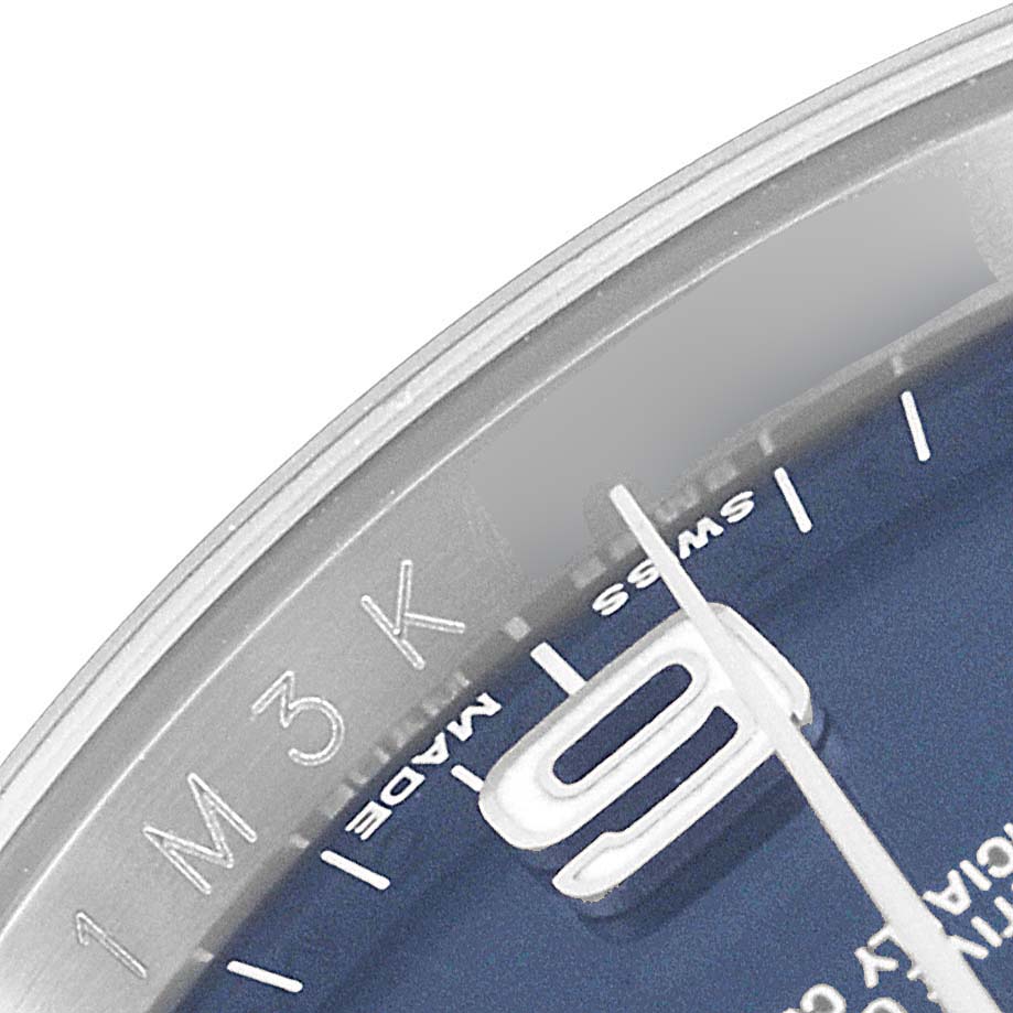 The image shows a close-up angle of the Rolex Oyster Perpetual 116000 Men's Stainless Steel Blue Dial 116000 Men's Stainless Steel Blue Dial watch's blue dial and part of the minute hand.
