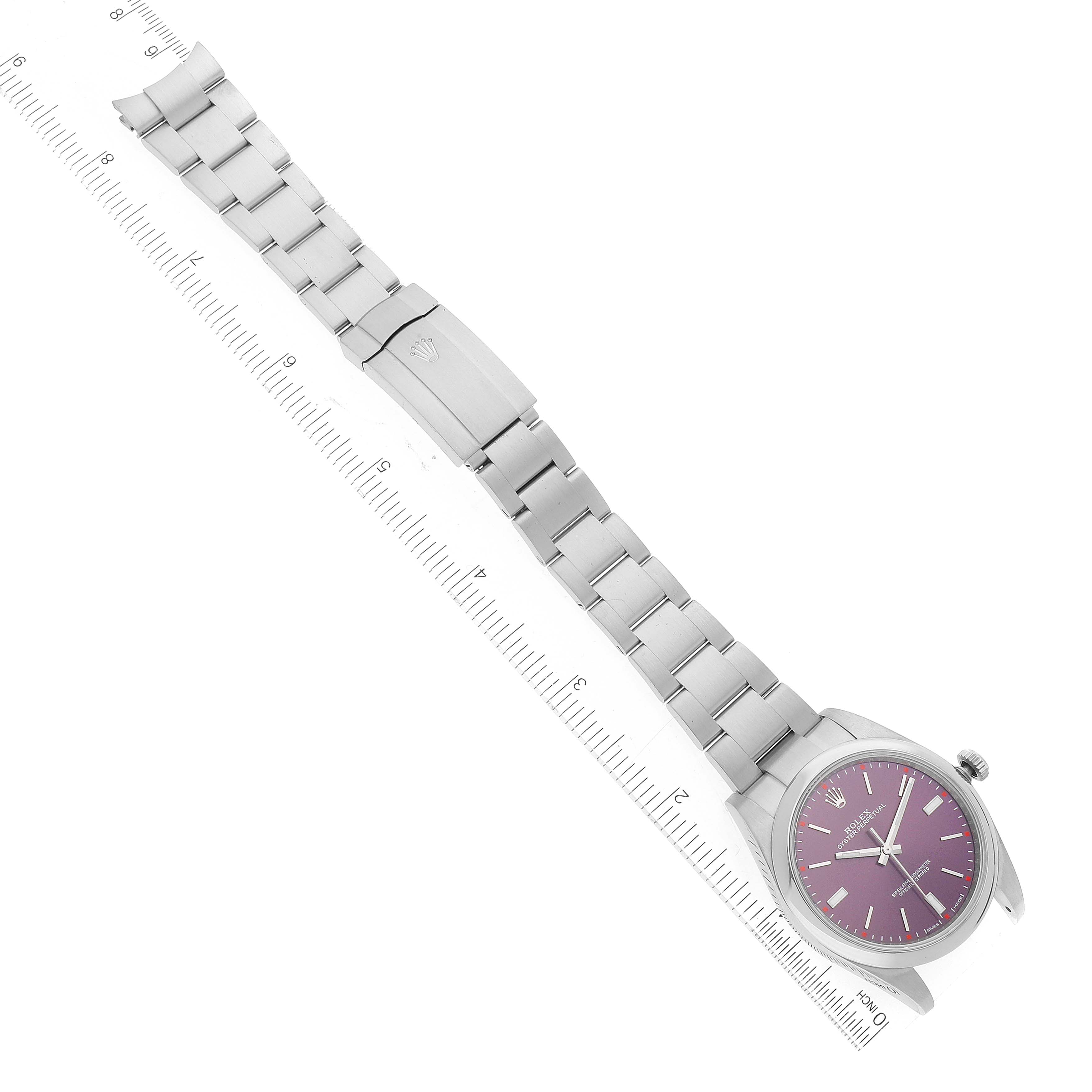 The Rolex Oyster Perpetual 114300 Men's Stainless Steel Burgundy Dial 114300 Men's Stainless Steel Burgundy Dial watch is shown from an overhead angle, displaying the face, clasp, and entire band length with a measuring ruler.