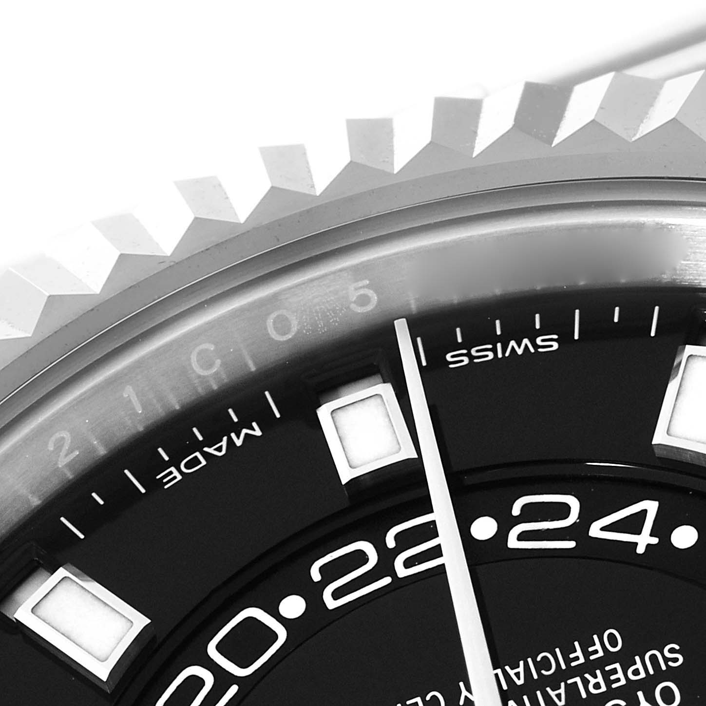 The image shows a close-up of the Rolex Sky-Dweller 326934 Men's Stainless Steel Black Dial 326934 Men's Stainless Steel Black Dial's bezel, partial dial, hour markers, and indication of Swiss Made.