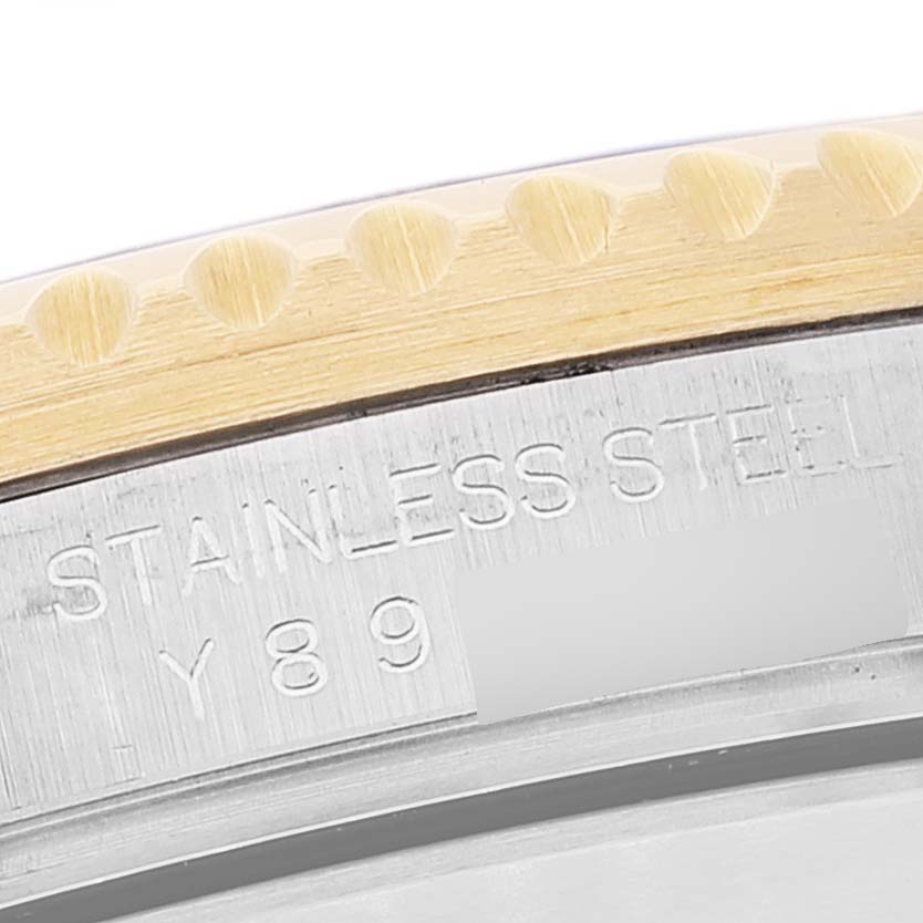 This image shows a close-up of the bezel and part of the casing of a Rolex Submariner 16613 Men
s Steel and Gold (two tone) Blue Dial 16613 Men
s Steel and Gold (two tone) Blue Dial, highlighting the "STAINLESS STEEL" engraving.
