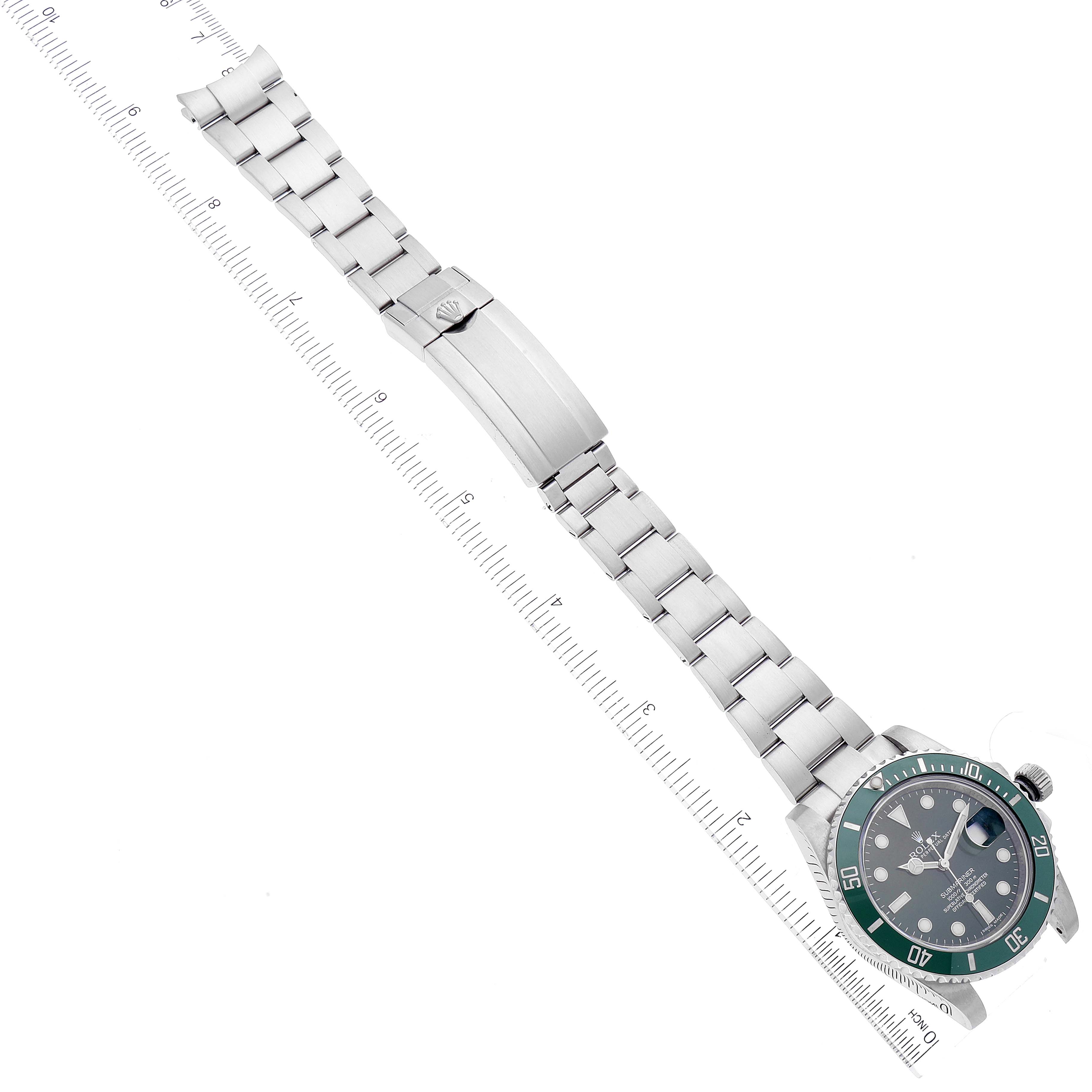 The image shows a top-down view of a Rolex Submariner 116610LV Men
s Stainless Steel Green Dial 116610LV Men
s Stainless Steel Green Dial watch, featuring the face, bezel, and full bracelet next to a ruler.