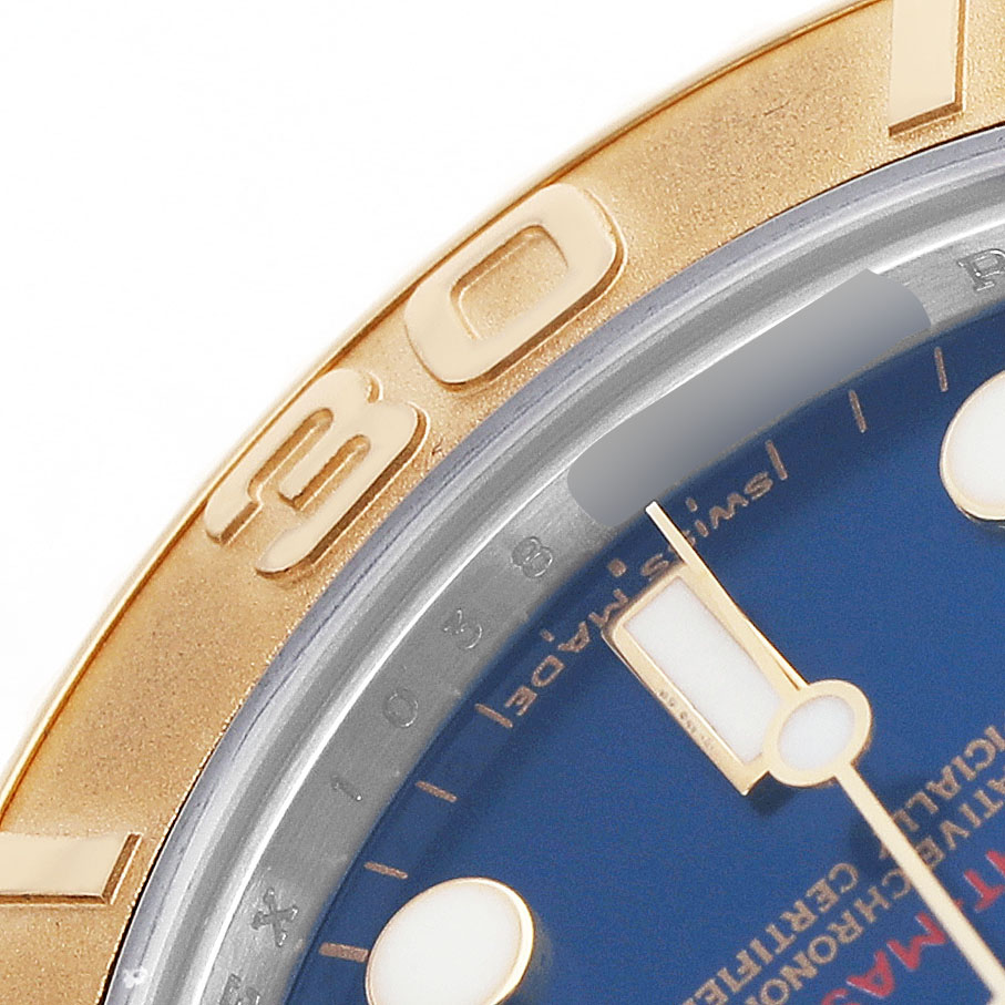 The image shows a close-up of the Rolex Yacht-Master 168623 Men's Steel and Gold (two tone) Blue Dial watch's gold bezel and blue dial with a partial view of the hands and markers.
