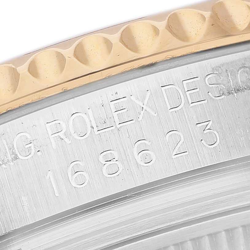 The image shows a close-up of the bezel and case edge of a Rolex Yacht-Master 168623 Men's Steel and Gold (two tone) Blue Dial watch, featuring engraved text.