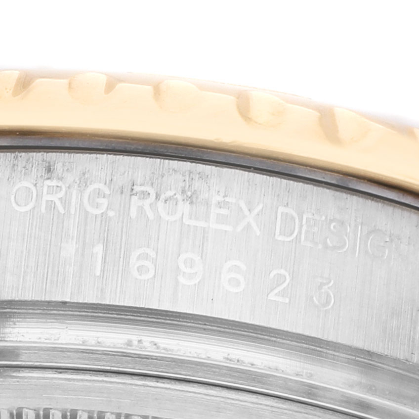 The image shows a close-up of the engraved side of the Rolex Yacht-Master 169623 Women's Steel and Gold (two tone) White Dial's metal case and bezel.