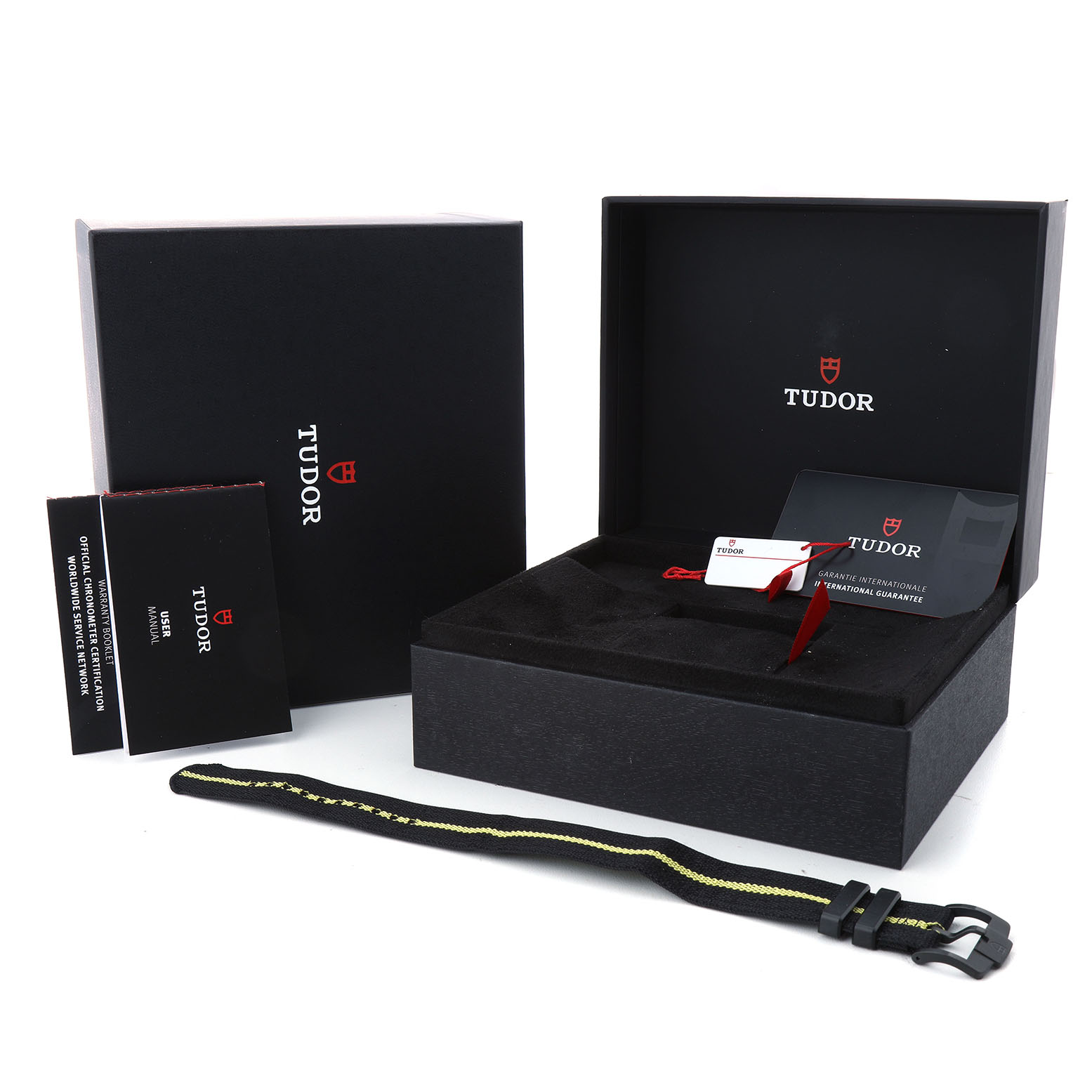 The image shows the Tudor Pelagos 25827KNJN Men's Titanium Black Dial model box, warranty card, booklet, and spare strap from a front angle.