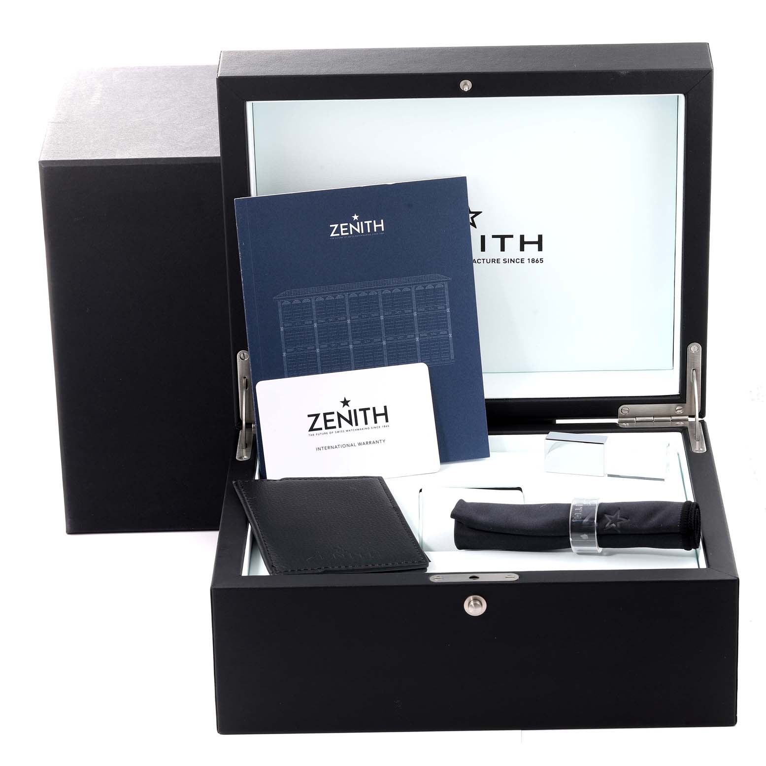 The image shows an open box with Zenith Chronomaster 03.3100.3600/21.M3100 Men's Stainless Steel Black Dial 03.3100.3600/21.M3100 Men's Stainless Steel Black Dial watch accessories, including booklets, warranty card, a cloth, and a leather pouch.