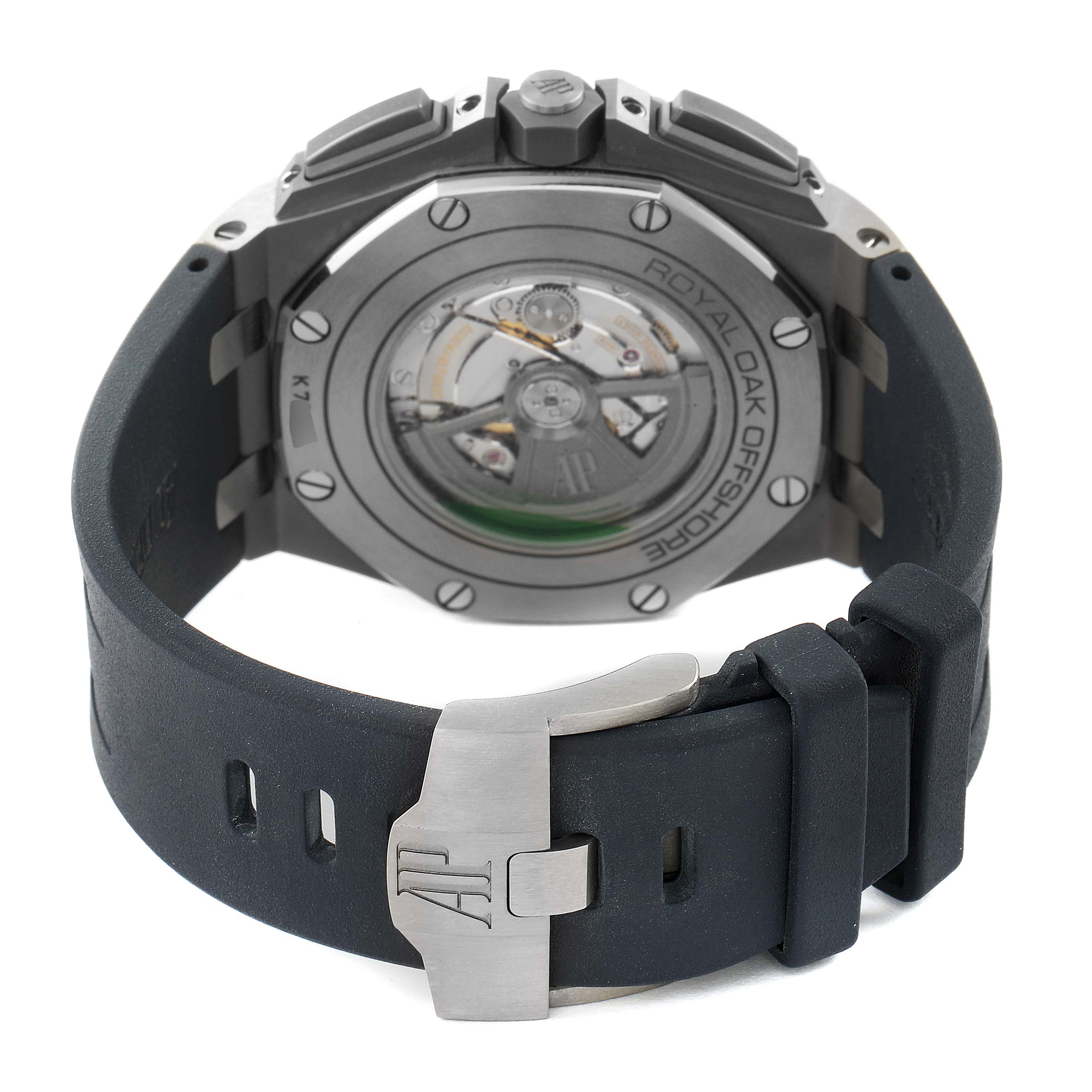 The image shows the back view of the Audemars Piguet Royal Oak Offshore 26400IO.OO.A004CA.02 Men's Titanium Grey Dial 26400IO.OO.A004CA.02 Men's Titanium Grey Dial watch, highlighting its mechanical movement and strap clasp.