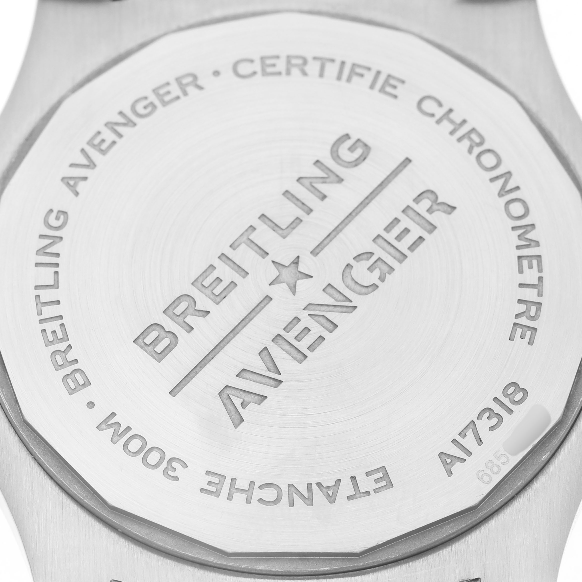 The image shows the back of a Breitling Avenger A17318 Men's Stainless Steel Black Dial watch, highlighting the engraved branding and model details.