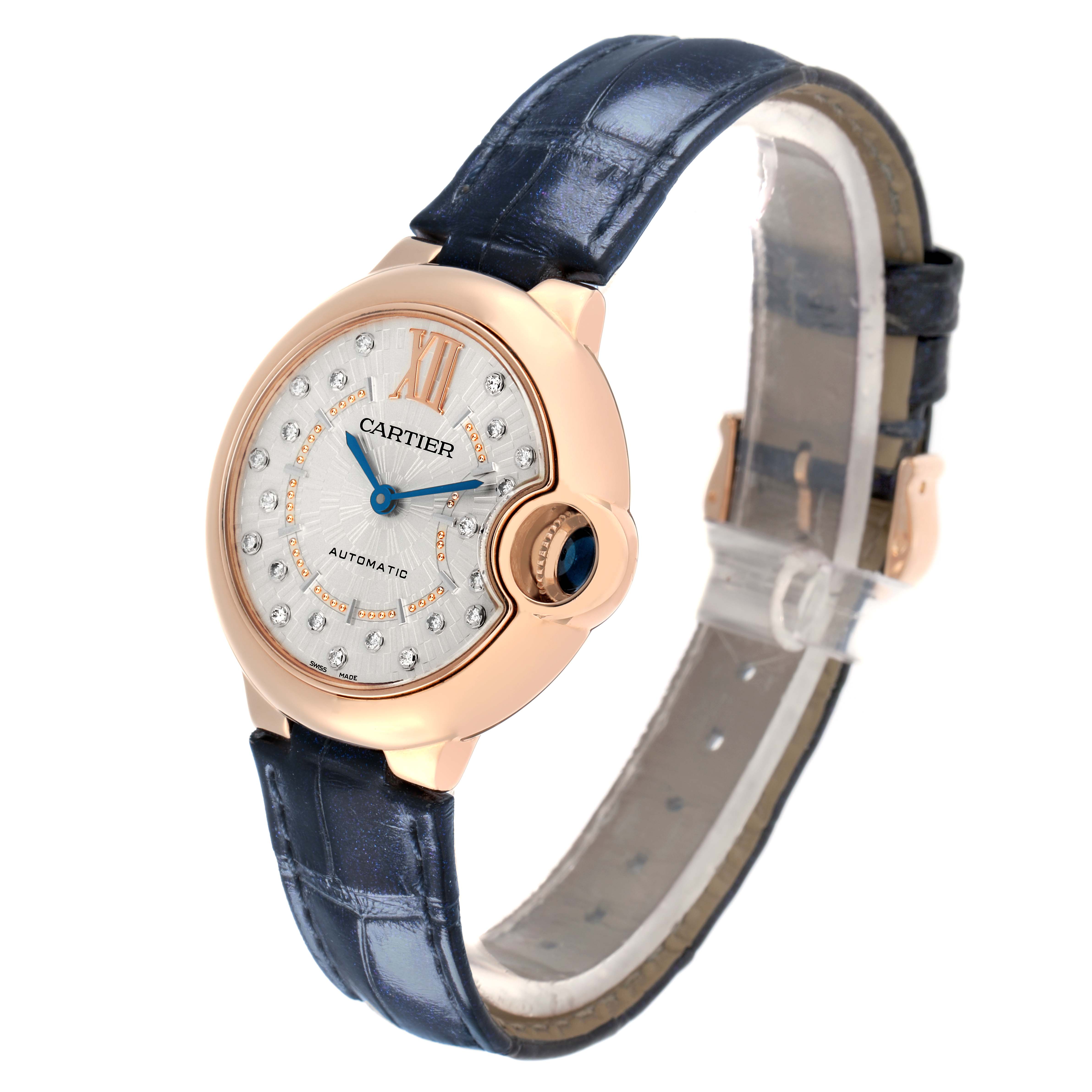 The Cartier Ballon Bleu WGBB0053 Women
s Rose Gold Silver Dial watch is shown at a slight angle, highlighting its face, crown, and blue leather strap.