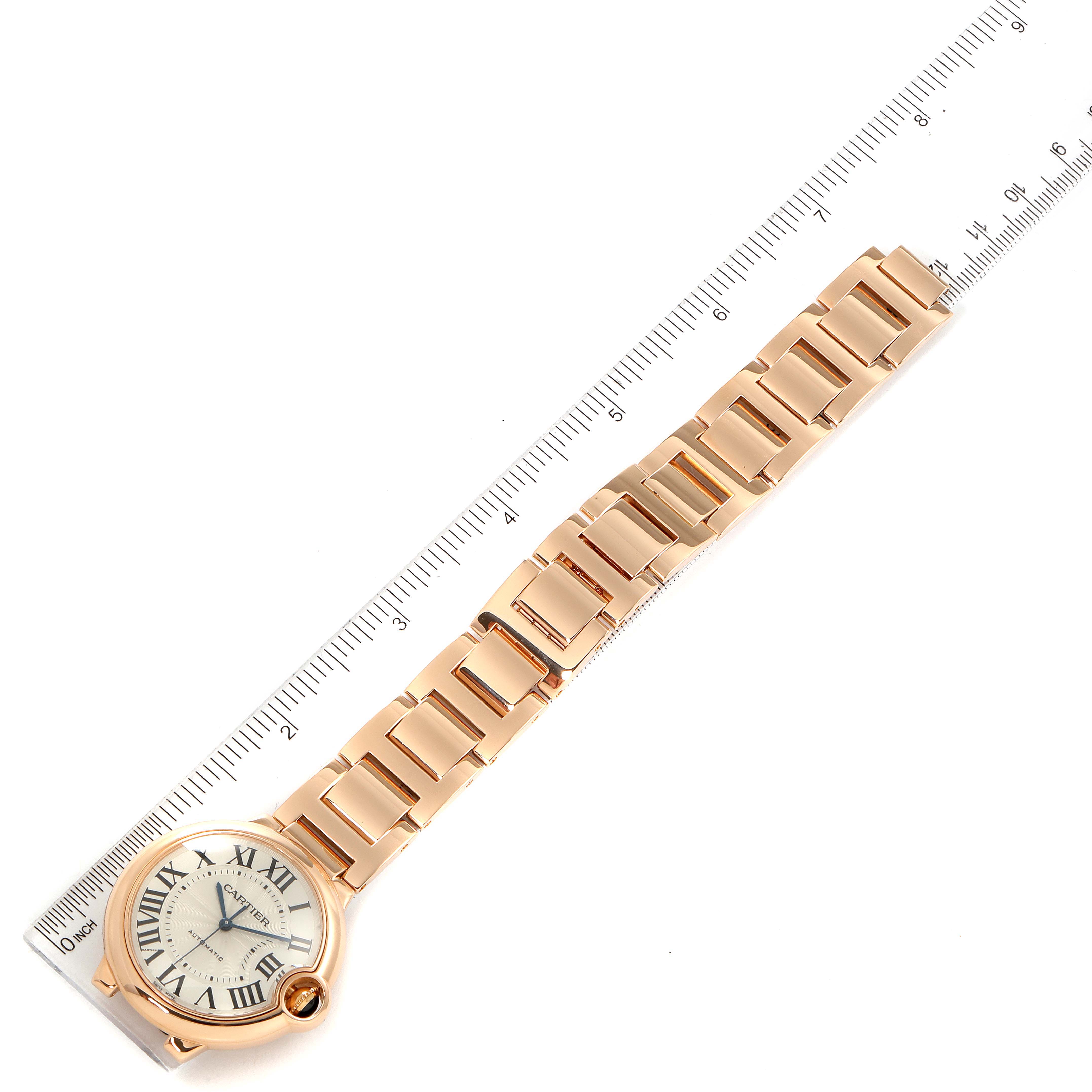 The image shows the Ballon Bleu de Cartier watch and its metal bracelet from a top-down angle, with a ruler for scale.