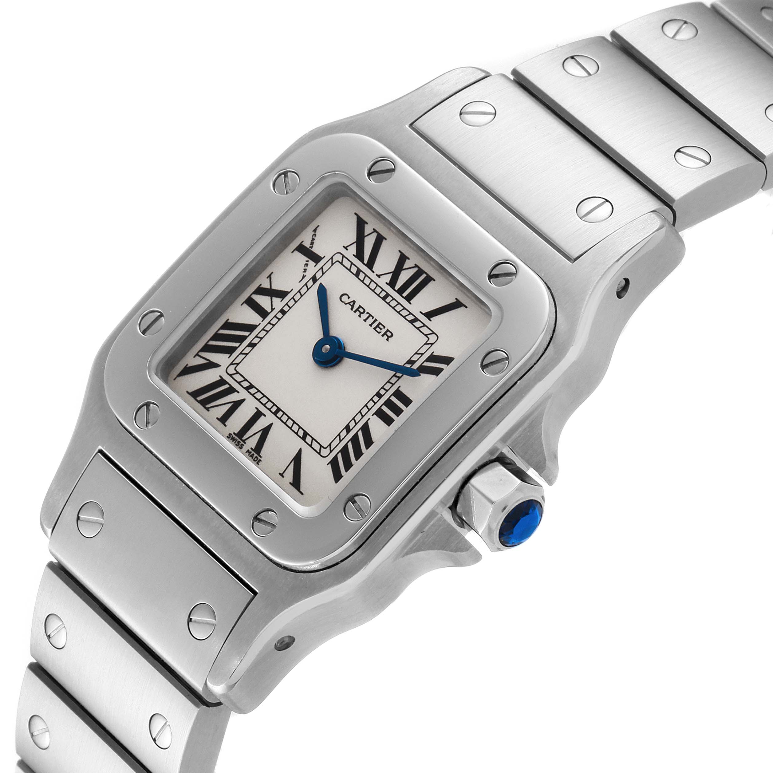 The image shows a close-up view of the Cartier Santos W20056D6 Women's Stainless Steel Silver Dial W20056D6 Women's Stainless Steel Silver Dial watch face, crown with blue gemstone, and part of the metal bracelet.