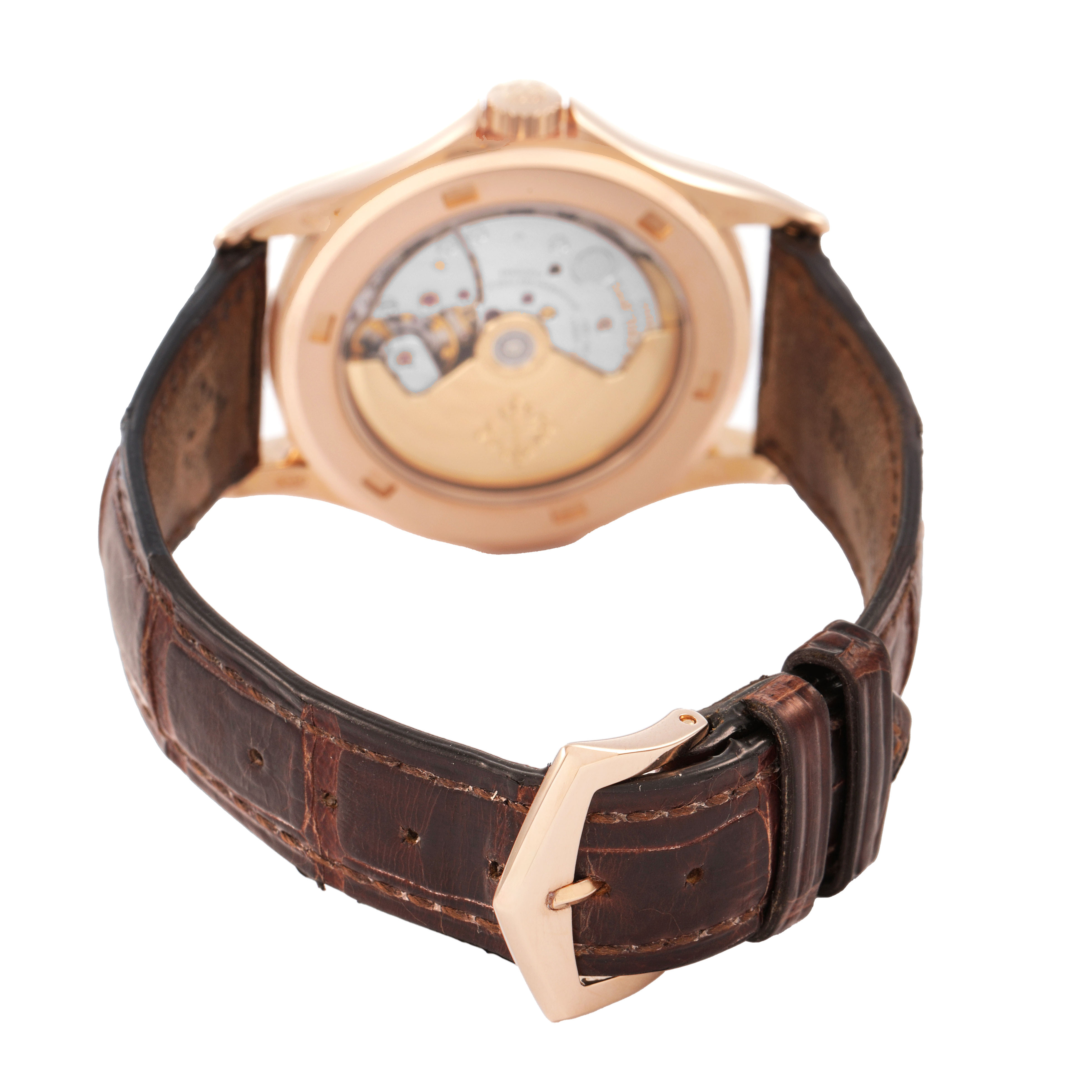 The image shows the back of a Patek Philippe Calatrava 5117R-001 Men's Rose Gold White Dial watch, highlighting the movement and brown leather strap with a buckle.