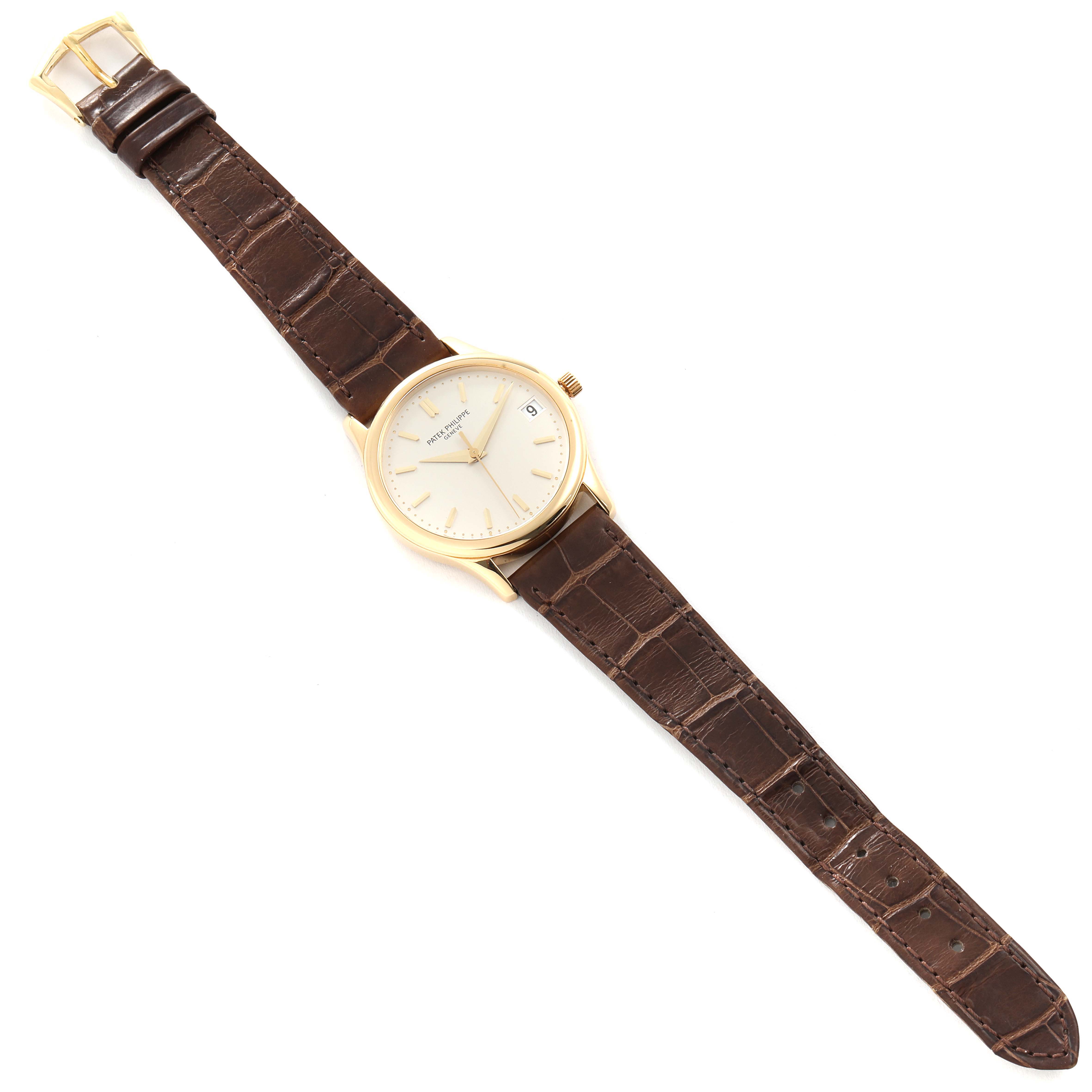 The image shows a Patek Philippe Calatrava 3998J Men's Yellow Gold Silver Dial 3998J Men's Yellow Gold Silver Dial watch, viewed from above, displaying the face, case, crown, and entire leather strap.