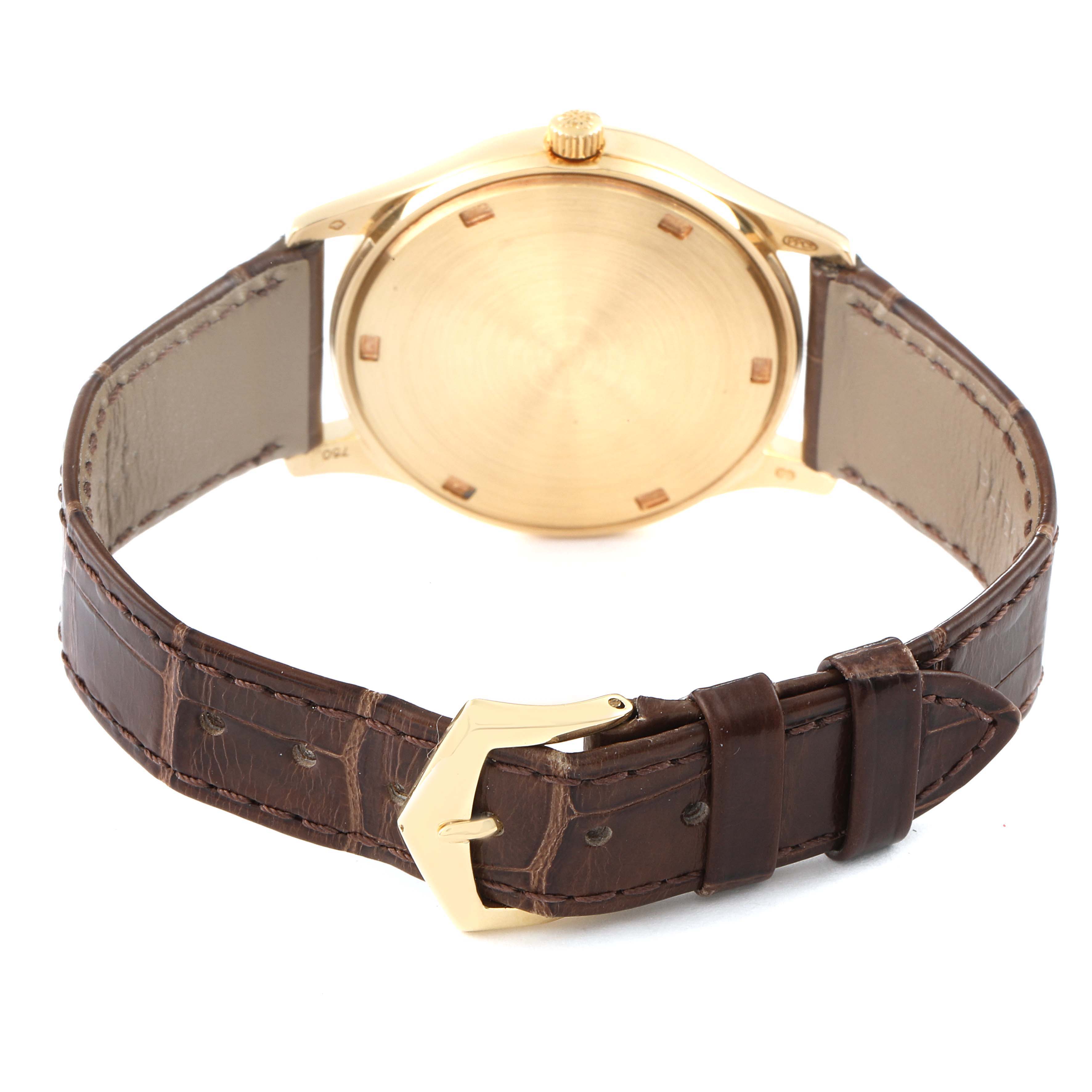 This image shows the back view of a Patek Philippe Calatrava 3998J Men's Yellow Gold Silver Dial 3998J Men's Yellow Gold Silver Dial watch, including its gold case and brown leather strap.