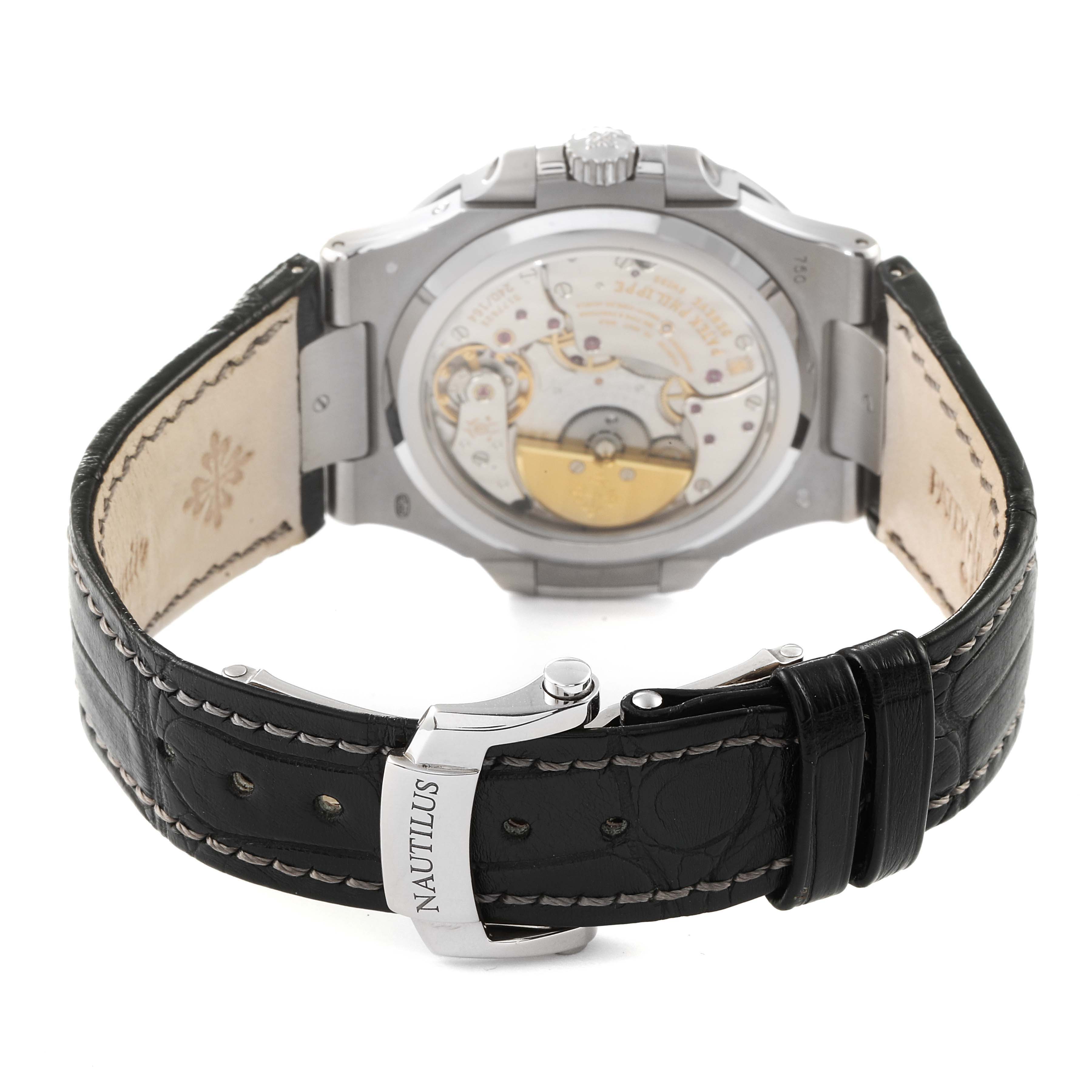 The image shows the back view of a Patek Philippe Nautilus 5712G/001 Men's White Gold Grey Dial 5712G/001 Men's White Gold Grey Dial watch, highlighting its open case back and leather strap with "Nautilus" on the clasp.