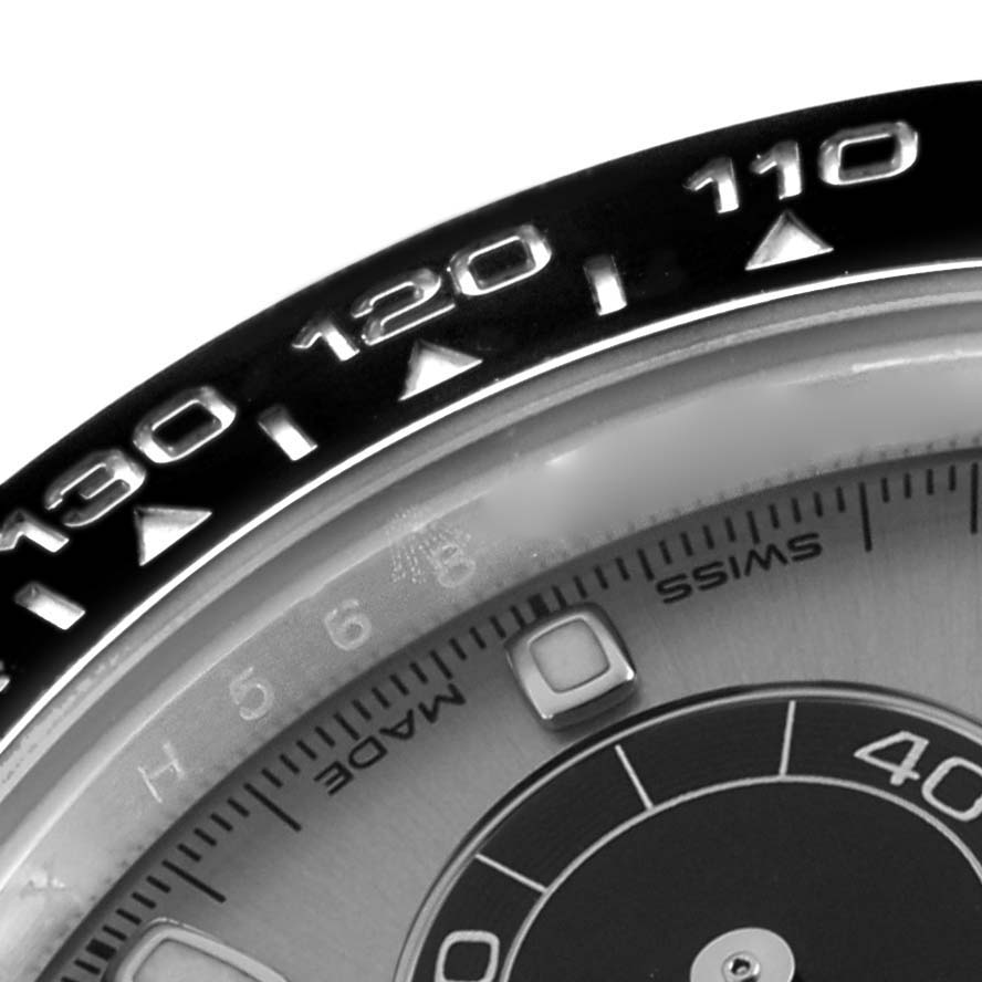 The image shows a close-up of the bezel and part of the dial of a Rolex Daytona 116519 Men
s White Gold Silver Dial watch, highlighting the tachymetric scale.