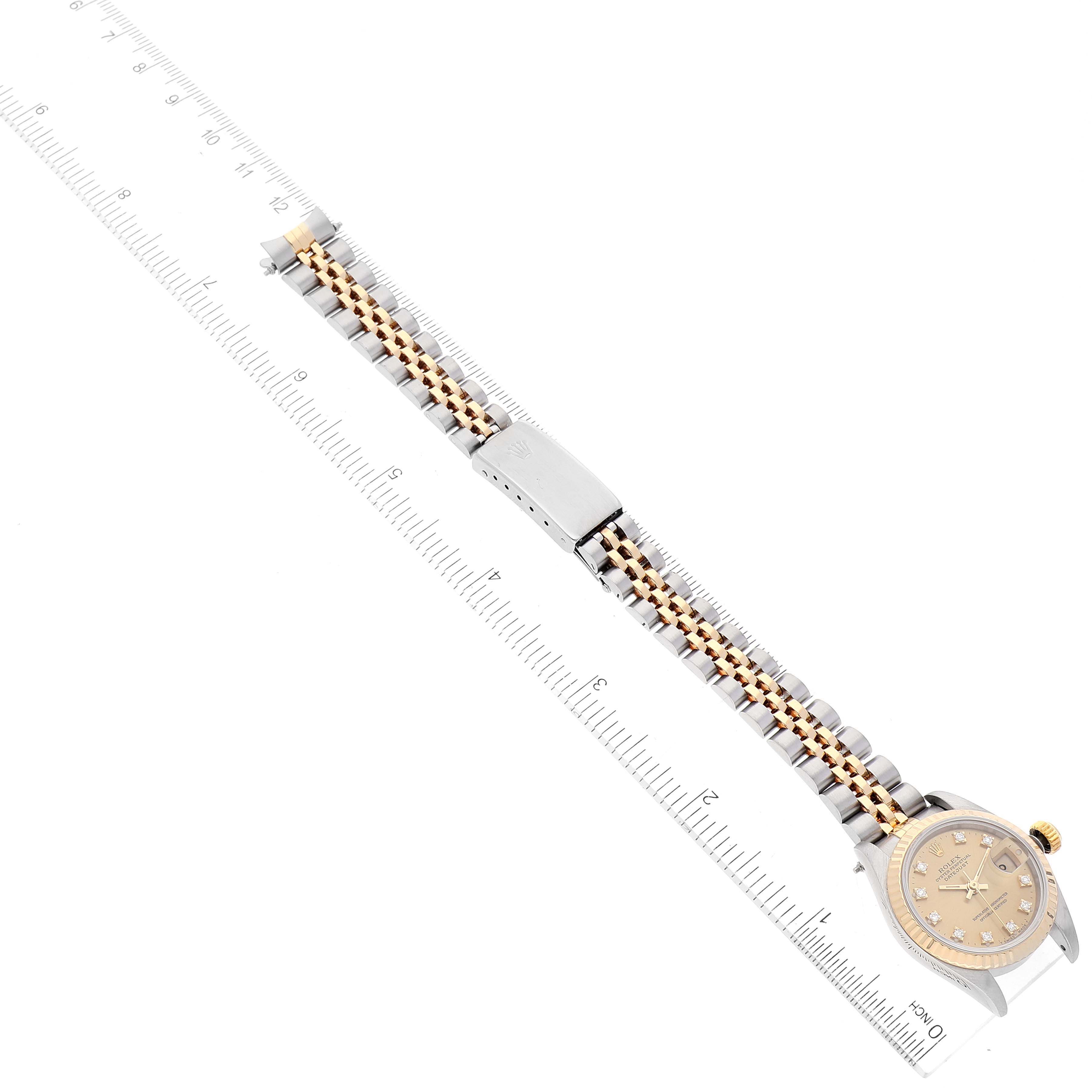 The Rolex Datejust 69173 Women's Steel and Gold (two tone) Champagne Dial 69173 Women's Steel and Gold (two tone) Champagne Dial watch is shown from a top-down angle, displaying the full length of the band and face on a ruler.