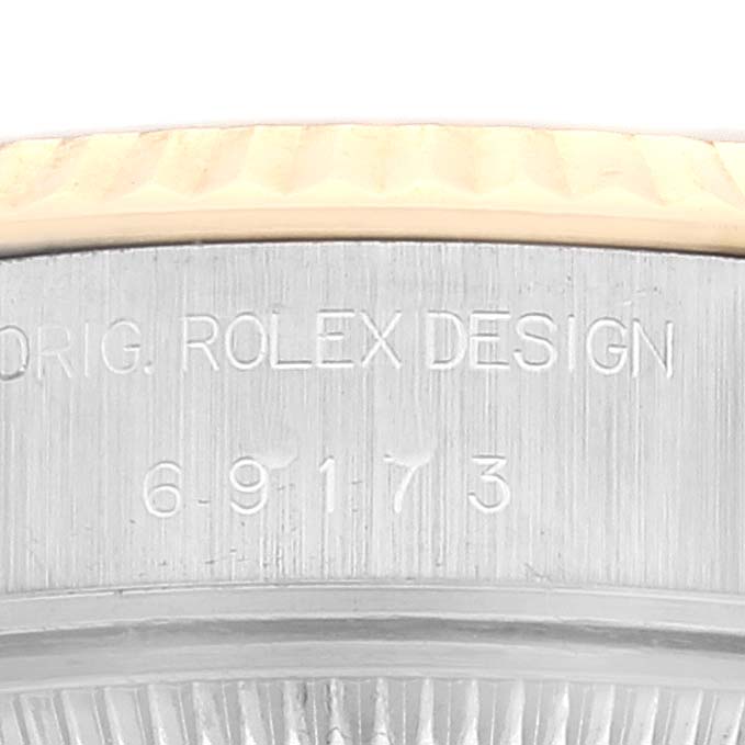 This image shows the serial number and "ROLEX DESIGN" engraving on the side of a Rolex Datejust 69173 Women's Steel and Gold (two tone) Champagne Dial 69173 Women's Steel and Gold (two tone) Champagne Dial watch case.