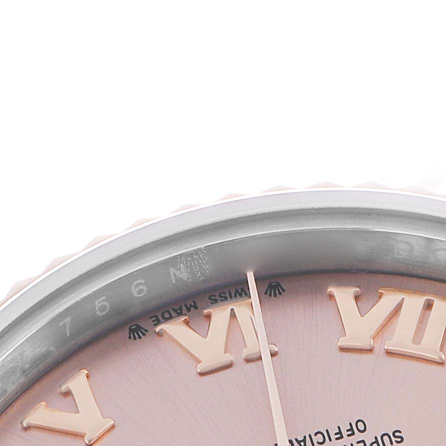 The image shows a close-up of a Rolex Datejust 279171 Women
s Steel and Gold (two tone) Pink Dial watch, focusing on the bezel, part of the dial, and Roman numeral hour markers.