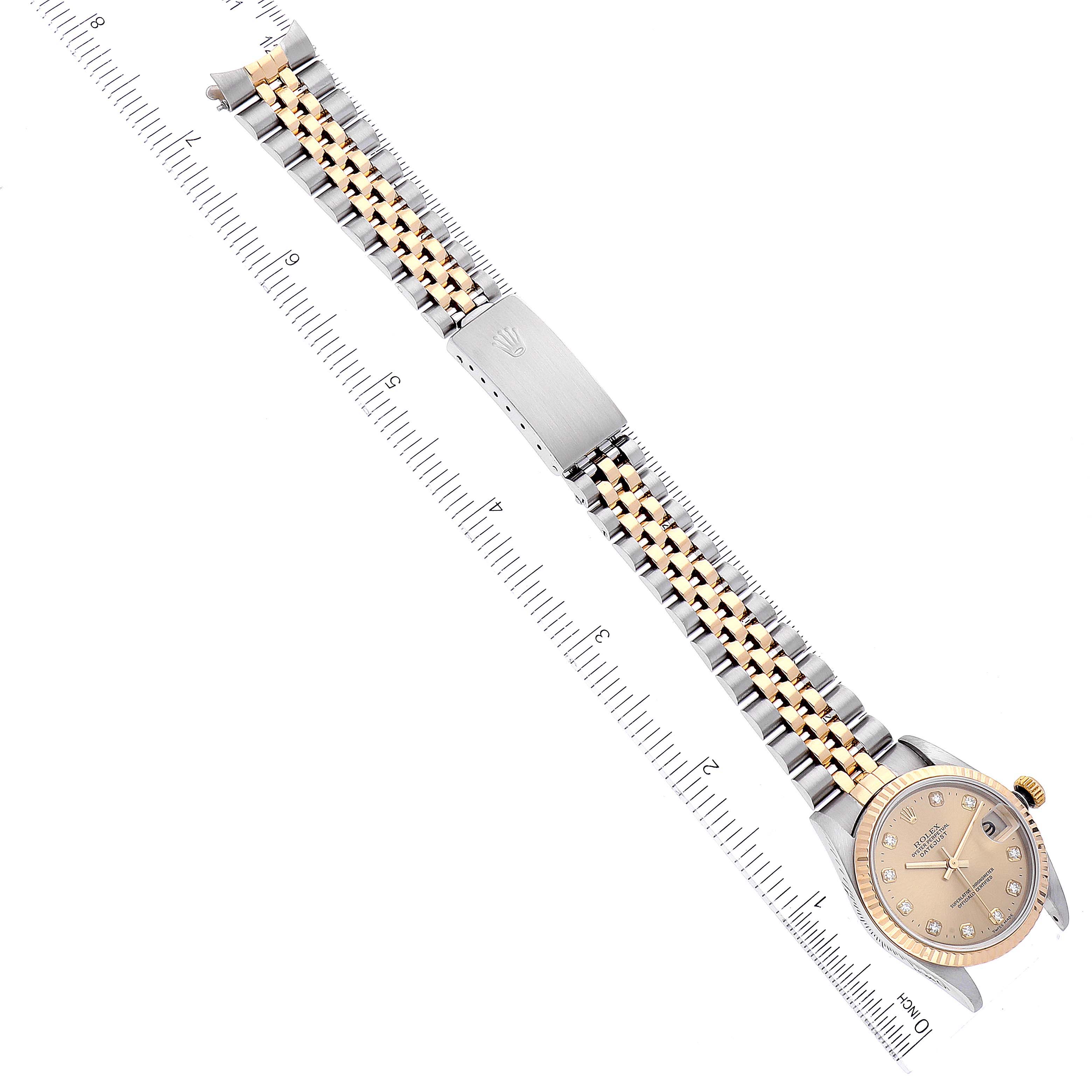 The image shows a Rolex Mid-Size 78273 Women
s Steel and Gold (two tone) Champagne Dial 78273 Women
s Steel and Gold (two tone) Champagne Dial model watch laying flat, displaying its face, bracelet, and clasp alongside a ruler for scale.