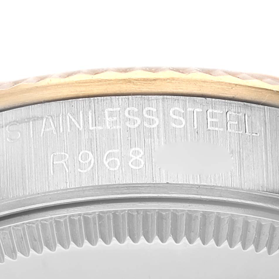 This close-up image shows the side of a mid-size Rolex watch case, including the bezel and part of the stainless steel body.