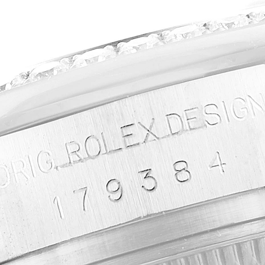 The image shows the engraved side of a Rolex Datejust 179384 Women
s Stainless Steel Silver Dial, focusing on the serial number and case design.