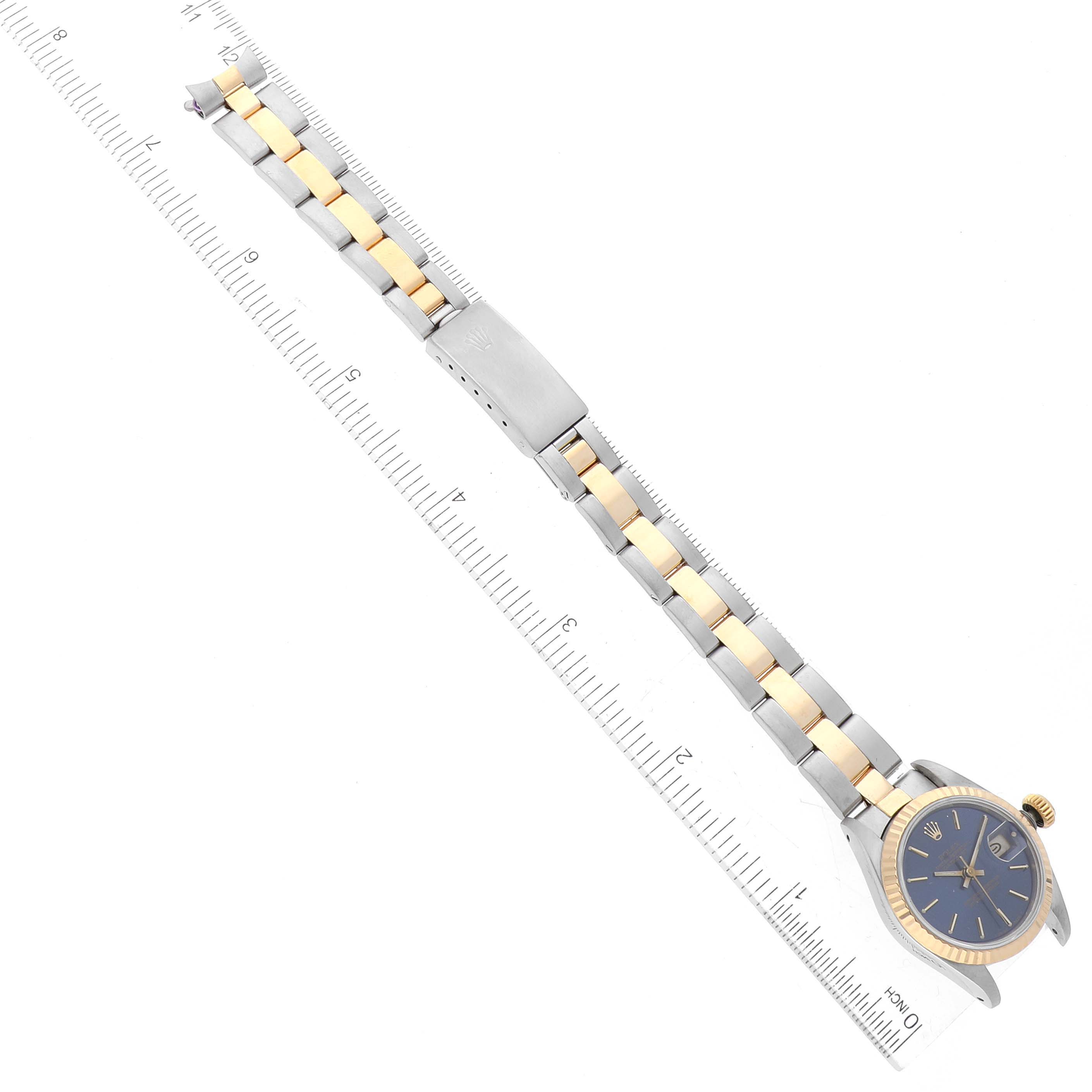 The image shows a Rolex Datejust 69173 Women's Steel and Gold (two tone) Blue Dial 69173 Women's Steel and Gold (two tone) Blue Dial watch from a top-down view, highlighting its band, clasp, and dial against a ruler.