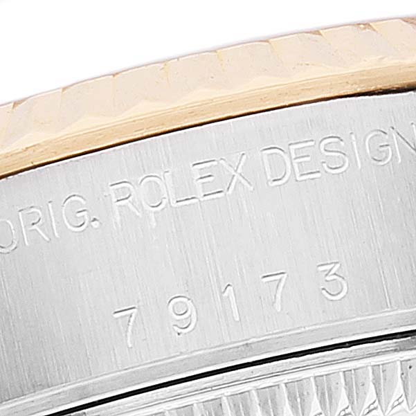 This close-up image of the Rolex Date 79173 Women's Steel and Gold (two tone) Champagne Dial 79173 Women's Steel and Gold (two tone) Champagne Dial model watch shows the engraved design number and part of the fluted bezel.