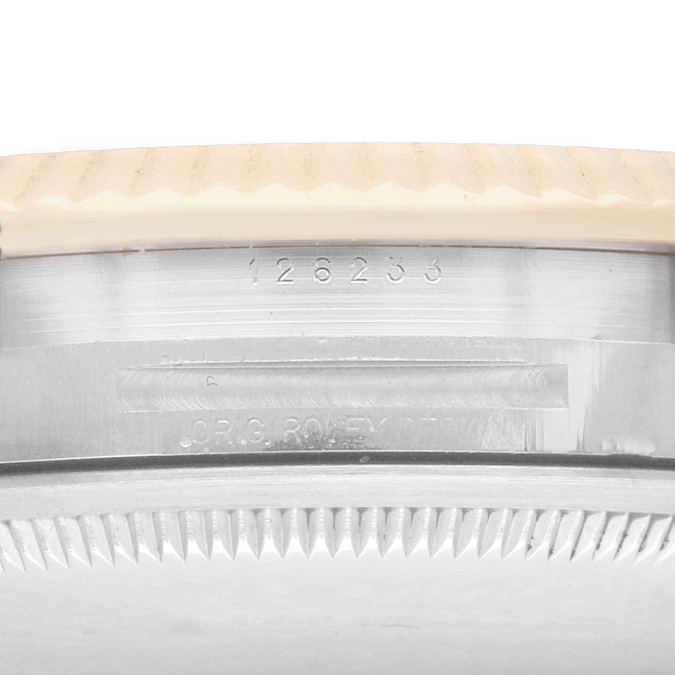 The image shows a side view of the Rolex Datejust 126233 Men
s Steel and Gold (two tone) Champagne Dial case, focusing on the serial number and the fluted bezel.