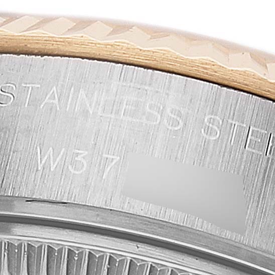This close-up image shows the textured bezel and part of the stainless steel caseback of a Rolex Datejust 69173 Women's Steel and Gold (two tone) Beige Dial 69173 Women's Steel and Gold (two tone) Beige Dial watch.