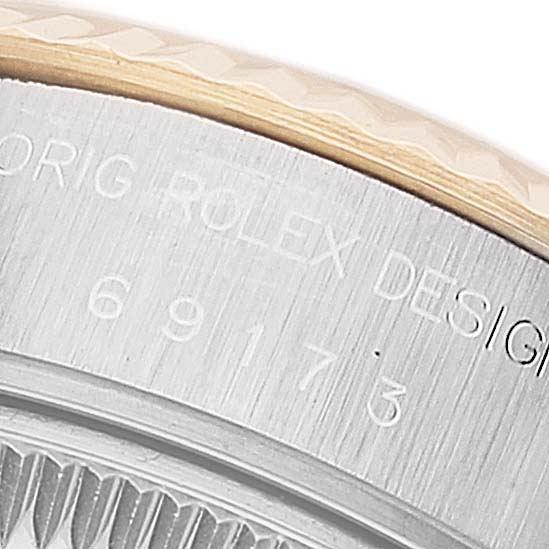This image shows a close-up of the Rolex Datejust 69173 Women's Steel and Gold (two tone) Beige Dial 69173 Women's Steel and Gold (two tone) Beige Dial model's case side, featuring engraved text and part of the bezel.
