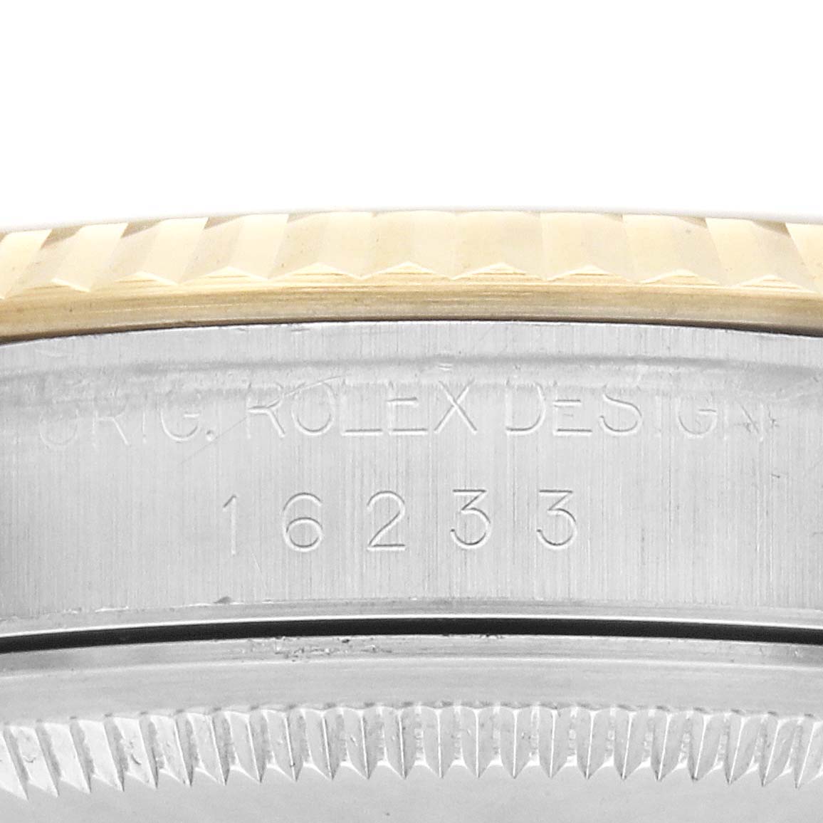 The image shows an engraving on the case side of a Rolex Datejust 16233 Men
s Steel and Gold (two tone) Champagne Dial, highlighting the model number "16233" and part of the bezel.