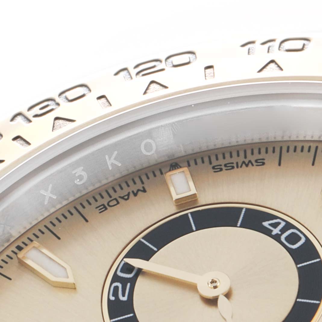 The image shows a close-up of the bezel and part of the dial of a Rolex Daytona 126503 Men
s Steel and Gold (two tone) Champagne Dial watch, focusing on numerals and hour markers.