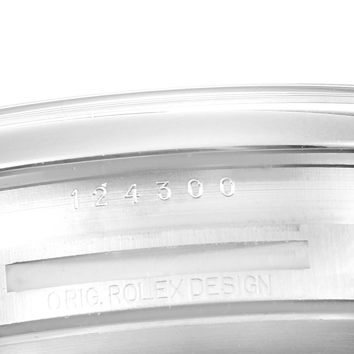 The image shows the side view of the case edge of a Rolex Oyster Perpetual 124300 Men
s Stainless Steel Black Dial, featuring engraved model and design numbers.