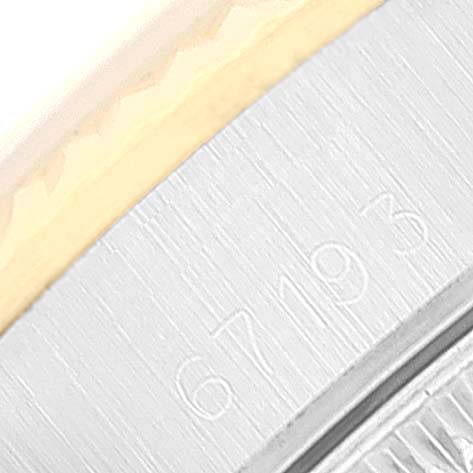 This image shows a close-up of the Oyster Perpetual Rolex watch bezel and part of the case with the model number engraved.