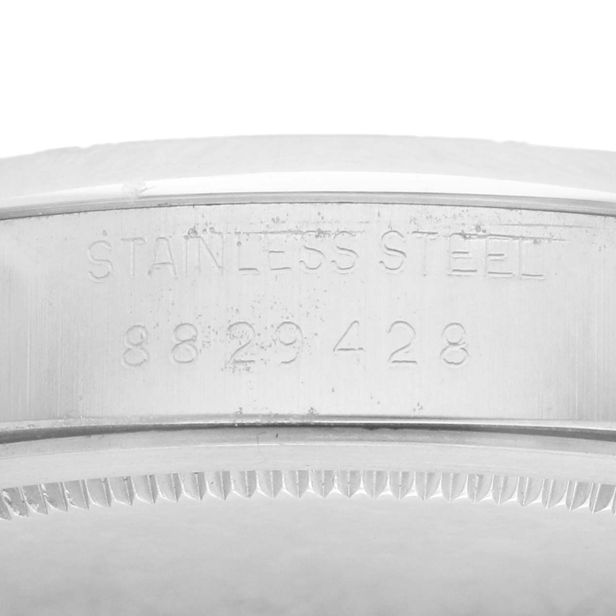 The image shows the side view of a Rolex Vintage Collection 6694 Men
s Stainless Steel Black Dial watch case, highlighting the engraved serial number and "Stainless Steel" label.